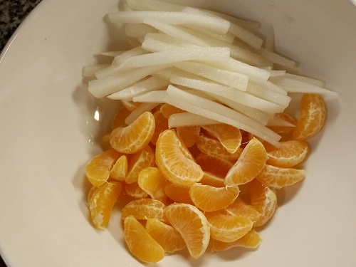 add daikons to the oranges in the bowl